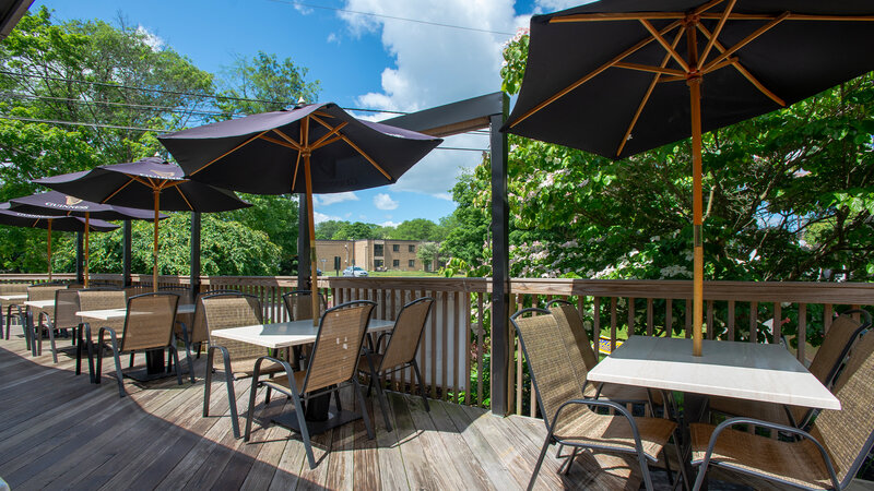 Patio dining area with tables with umbrellas - The Village Inn - Gallery Photo 3 Patio dining area with tables with umbrellas