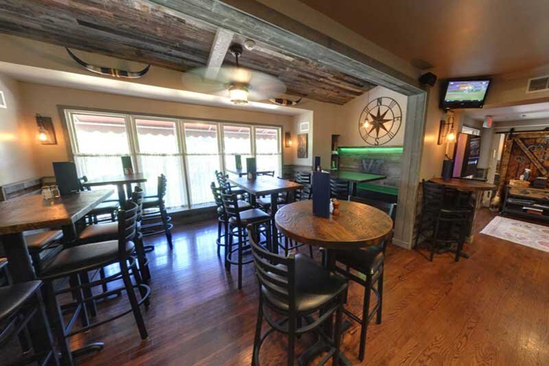 Bar seating area with high-top tables and chairs - The Village Inn - Gallery Photo 1 Bar seating area with high-top tables and chairs