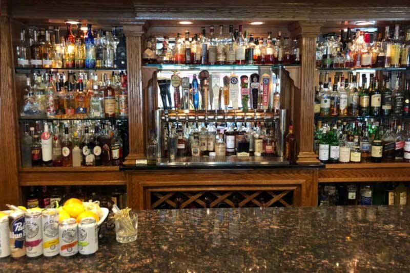 Bar counter with view of liquor bottles - The Village Inn - Gallery Photo 2 Bar counter with view of liquor bottles